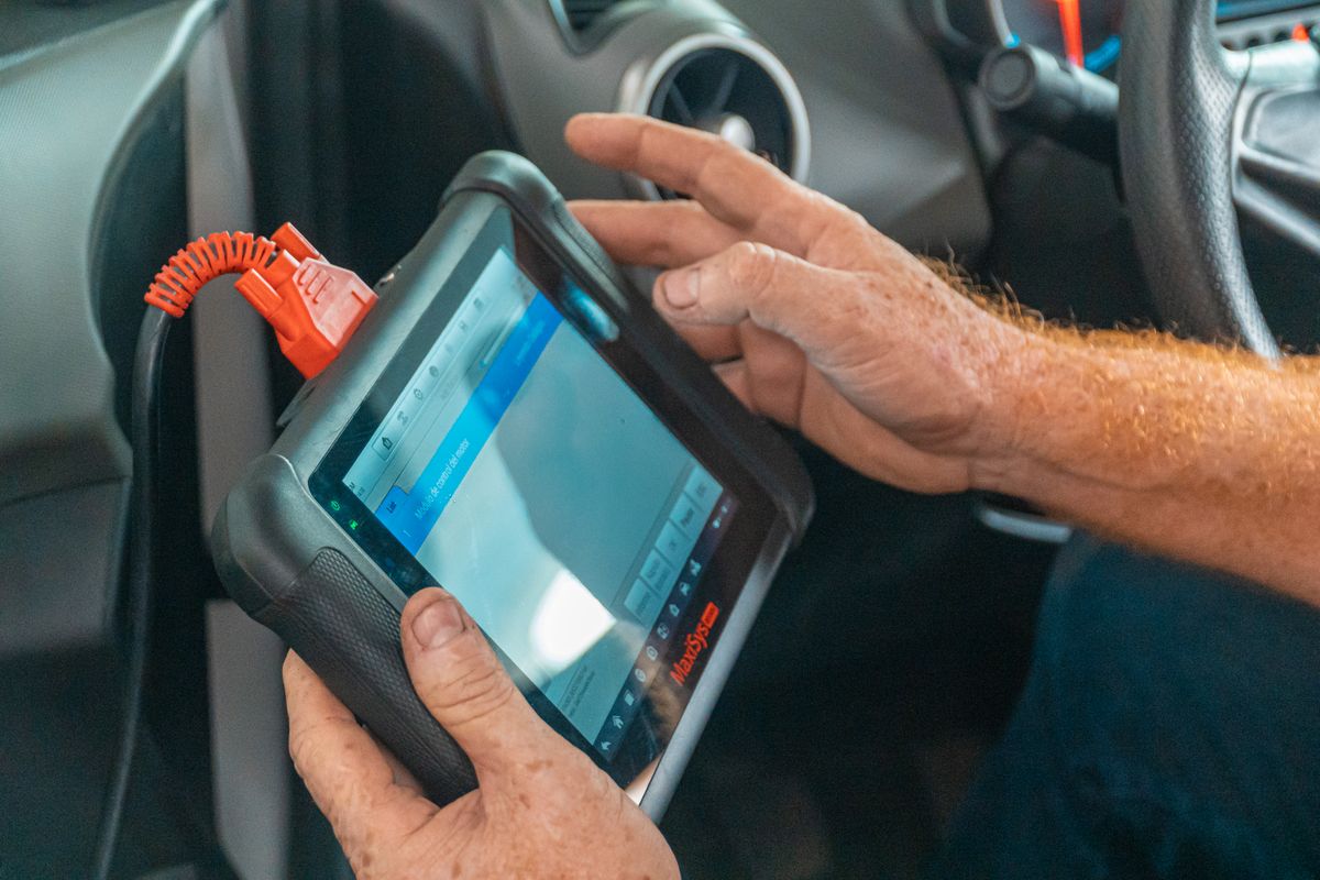 Mechanic using a diagnostic scan tool in a vehicle